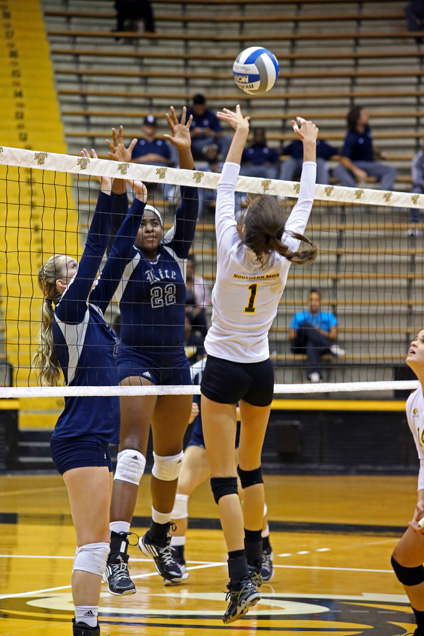 Freshman Kelsey Chambers jumps for the ball as teammates Jasmine Crowell, a senior, and Mary Pursell, a junior, look on. The Lady Eagles were defeated by Rice on Friday September 26, 2014. Jessica King/ Archives