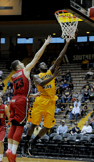 Junior, Norville Carey, reaches for the basket against Western Kentucky player Justin Johnson during the Golden Eagles home game Saturday night. The  Eagles fall, 73-62.