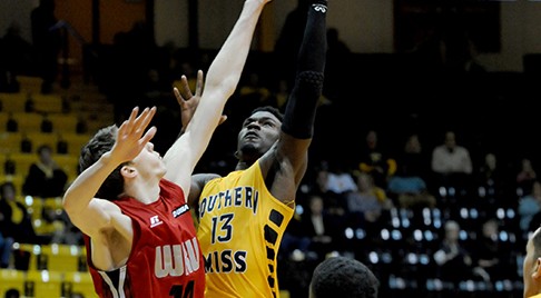 Redshirt senior Chip Armelin reaches for the ball against Western Kentucky player Ben Lawson as the Golden Eagles play Saturday night in the Reed Green Coliseum.  The Eagles fall, 73-62.