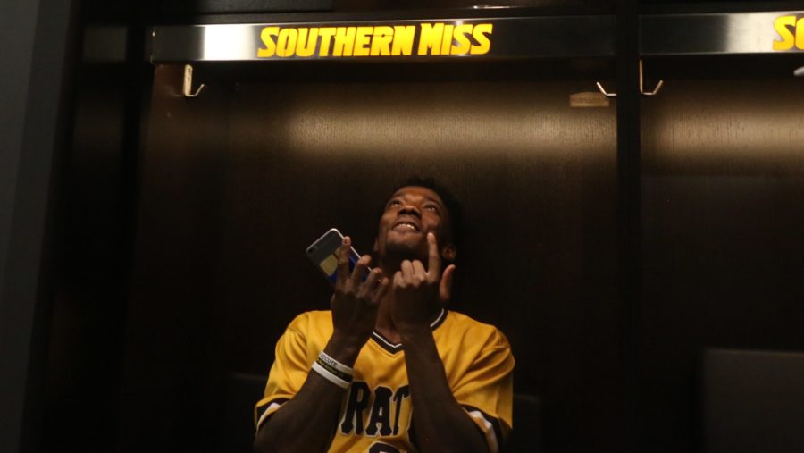 Junior receiver Tyre'oune Holmes looks up to his locker during the unveiling of renovations on Aug. 24.