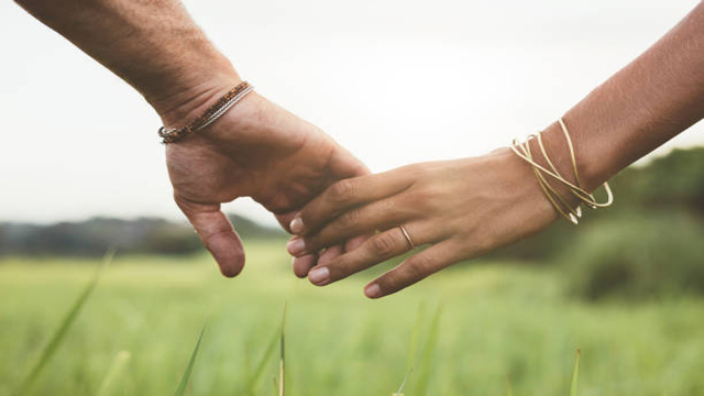 Loving couple holding hands in a field
courtesy