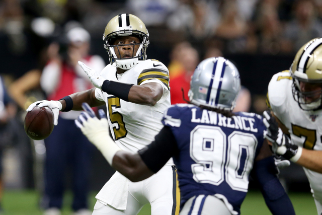 New Orleans Saints quarterback Teddy Bridgewater looks to throw under pressure by Dallas Cowboys defensive end Demarcus Lawrence in the first quarter at the Mercedes-Benz Superdome.