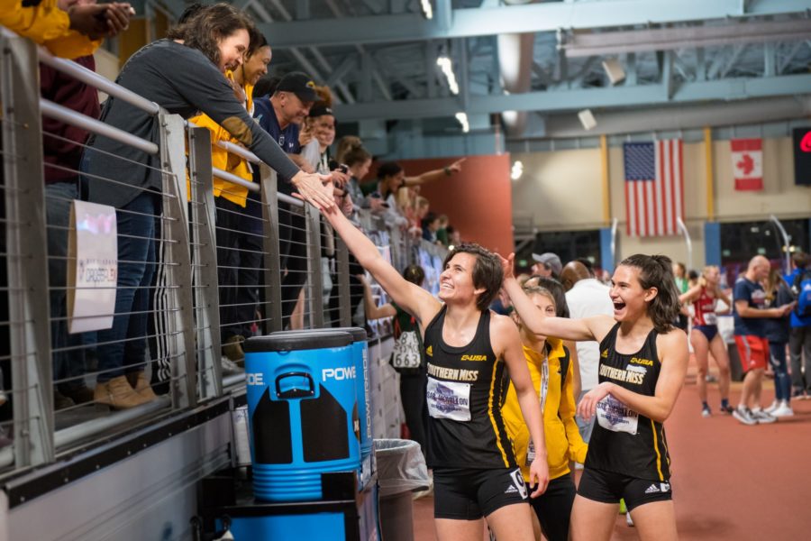 Twins Sarah and Savannah McMillon celebrate gold in the womens DMR with their mother and team.
Photo by Michael Sandoz