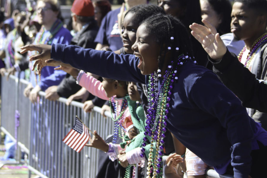 A parade attendee tries to get the attention of people on floats as the floats drive by during Hattiesburgs Caerus Parade for Mardi Gras on Hardy Street on February 18, 2023.
