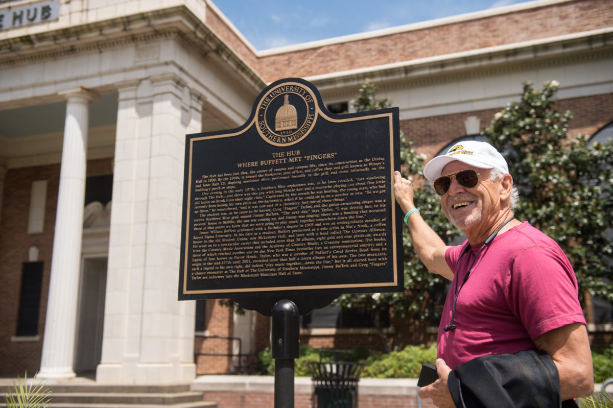 Legendary singer and USM alum Jimmy Buffett stands at the sign on campus in his honor in 2018.