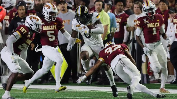 USM's Rodrigues "Dreke" Clark runs between Texas State defenders.