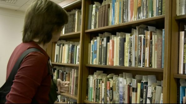 A USM student searches for a book in the library.