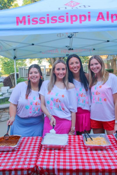 Members of Pi Phi serve toppings for baked potatoes.