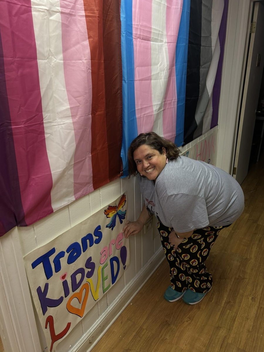 Alicia Pacheco Brown displays colorful artwork celebrating LGBTQ representation, created by members of the Spectrum Center’s youth group.