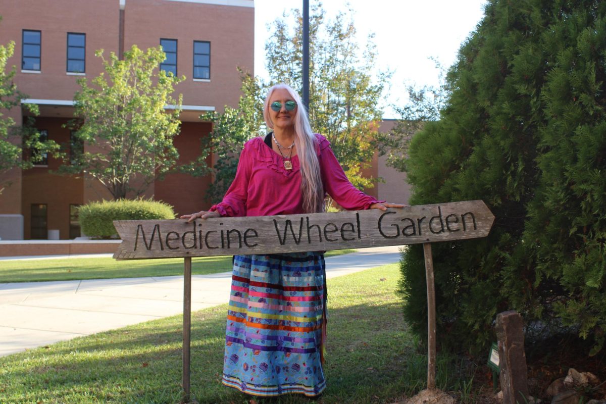 Dr. Tammy Greer standing by the Medicine Wheel Garden on USM campus