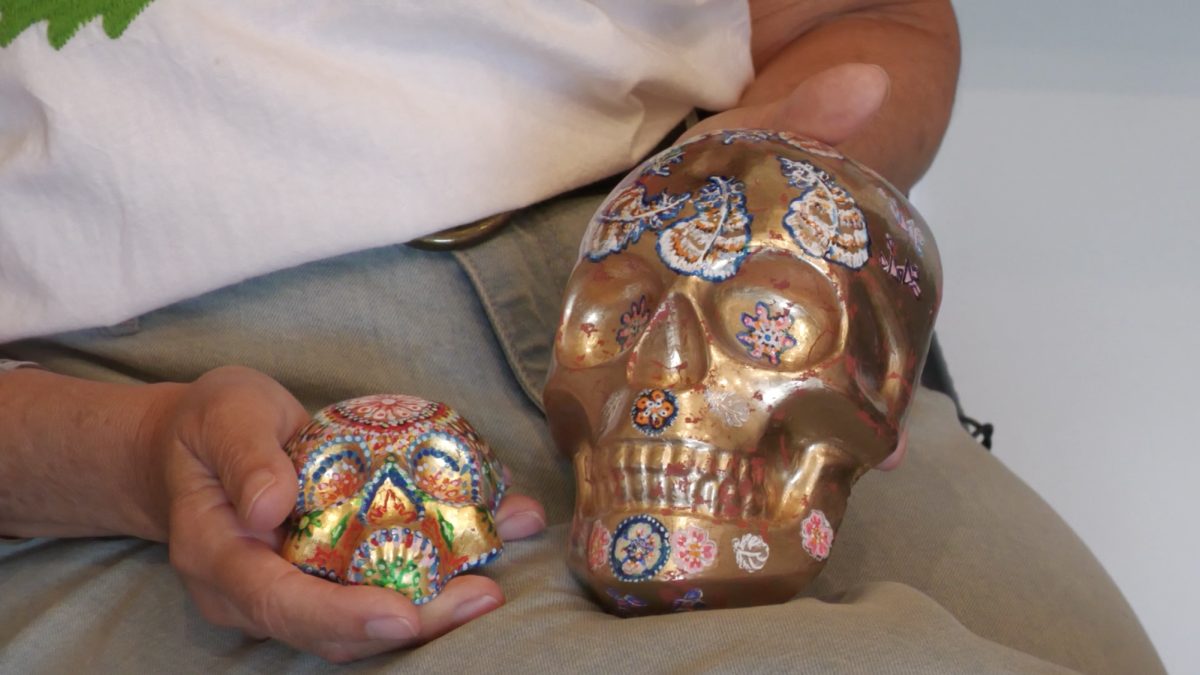 Vice President of the MS Latinx Art Asssociation holding sugar skulls for their upcoming Day of the Dead event. 