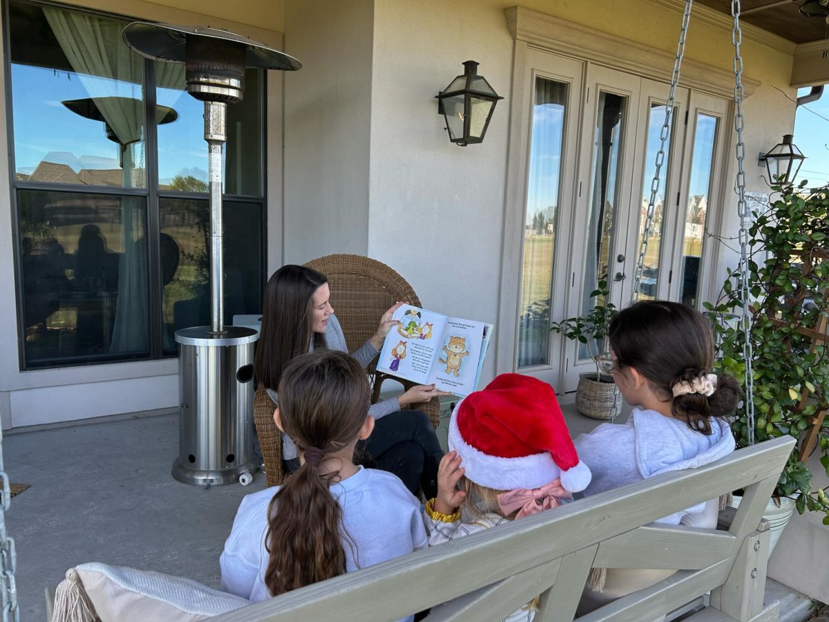 Sam Boudreaux reading her new book to children.