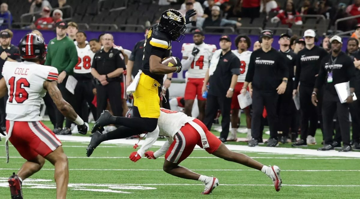 A USM football player dodges Western Kentucky defenders during the New Orleans Bowl. 