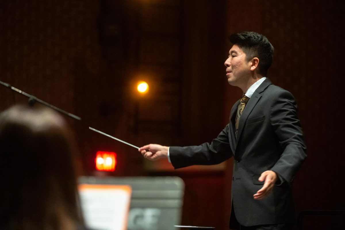 Travis Higa, director of bands at USM, leads musicians during a performance event.