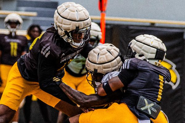 Golden Eagles football players tackle each other during the showcase.